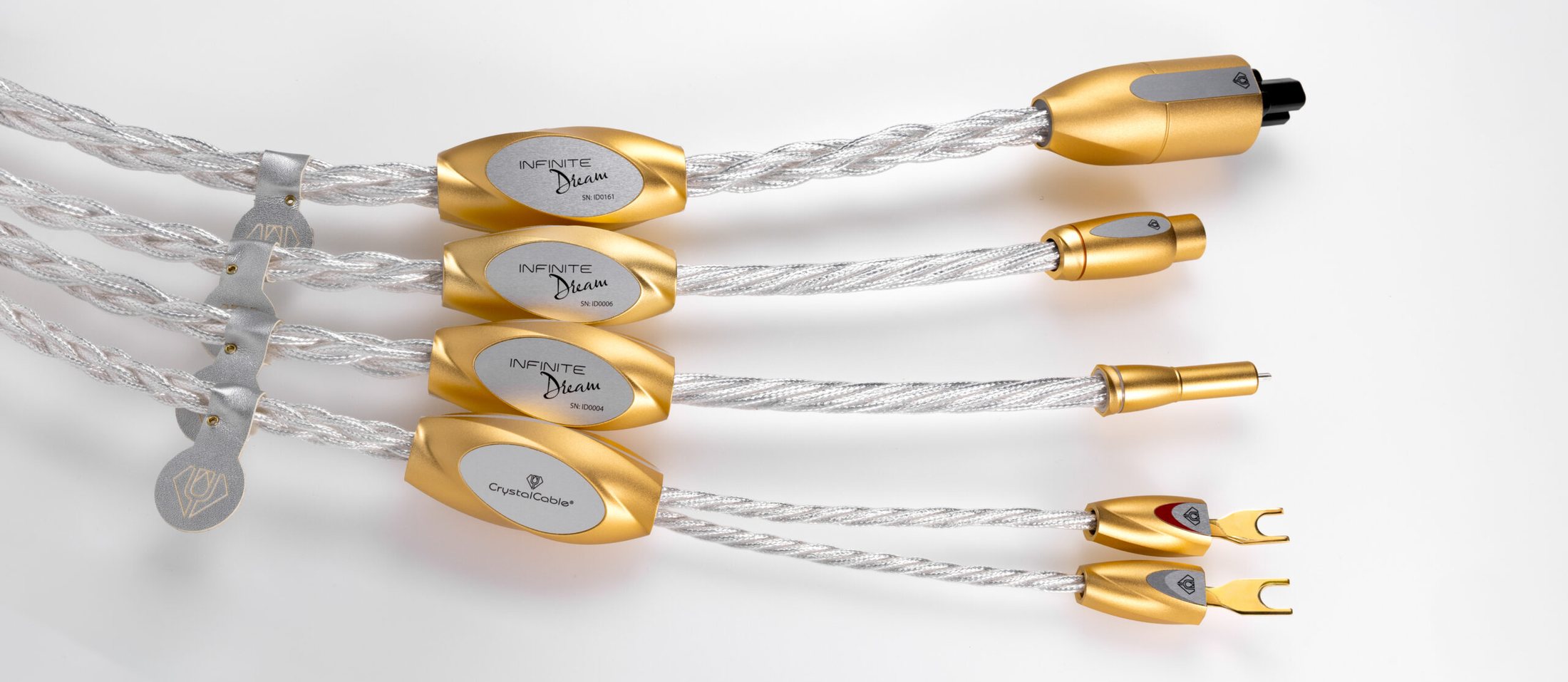 Four Infinite Dream cables side by side, their gold barrels and plugs on white