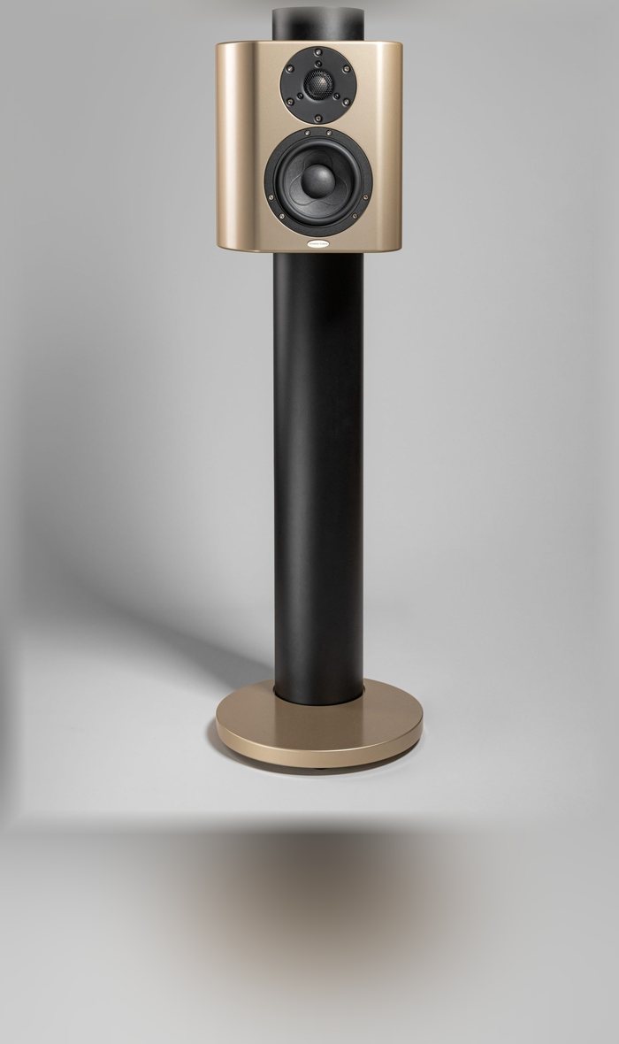 A Minissimo Forte loudspeaker in gold on its black stand