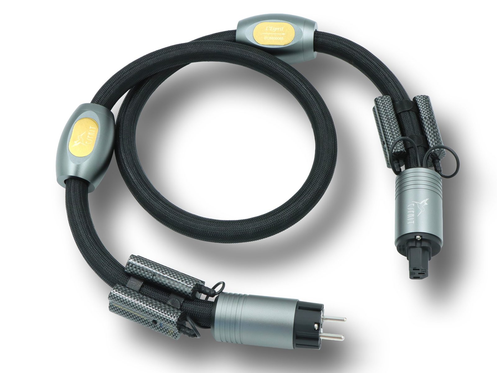 An Esprit L'Esprit power cable coiled on white, its two plugs and its gold badge