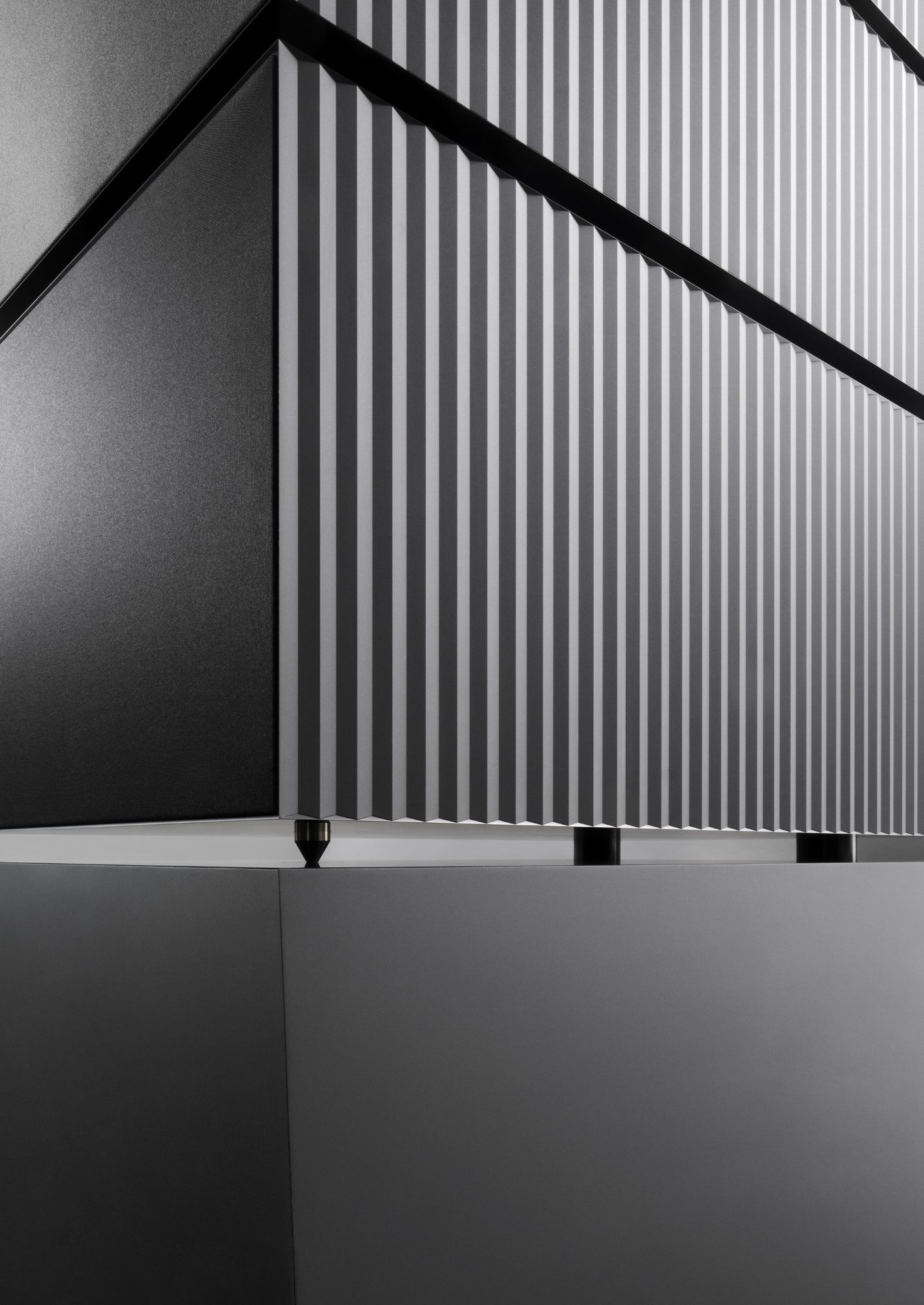 The ribbed flank of a loudspeaker on its plinth