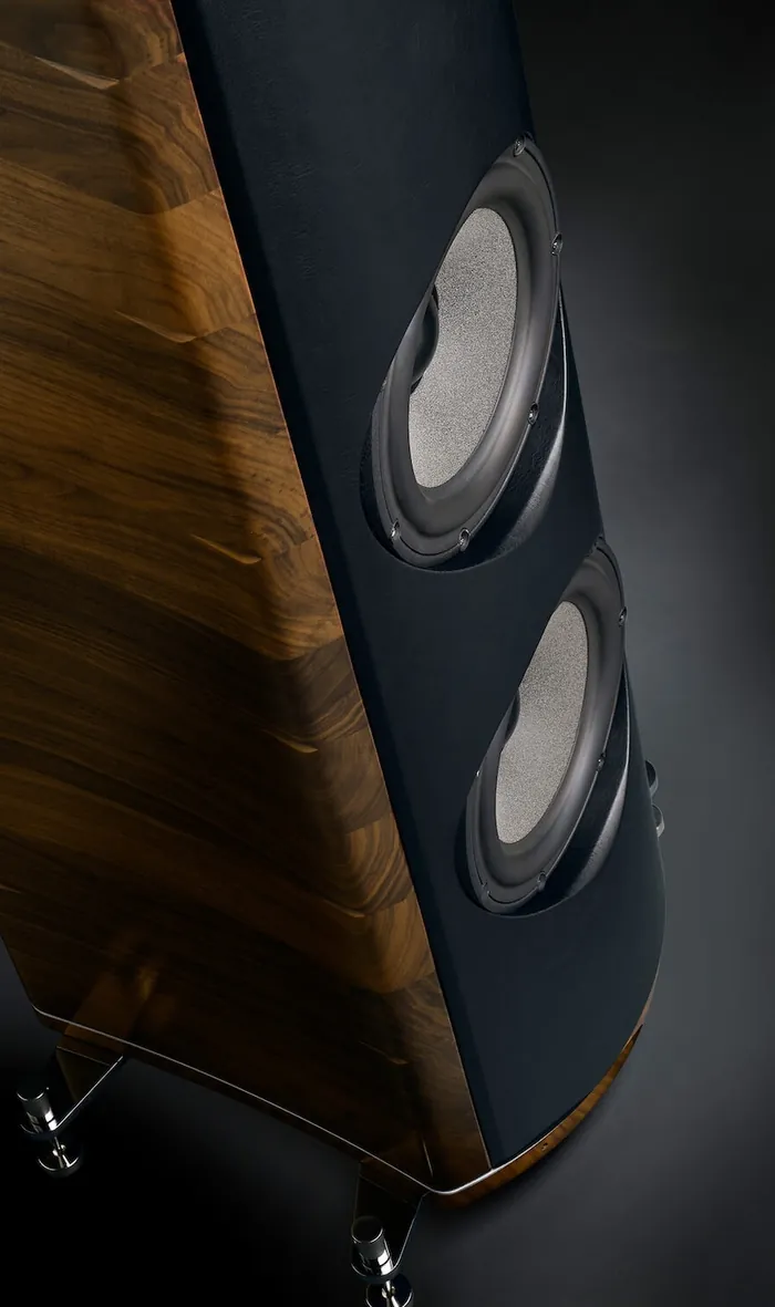 The side of an Accordo Unica loudspeaker, close: two woofers in a black front, the cabinet in walnut