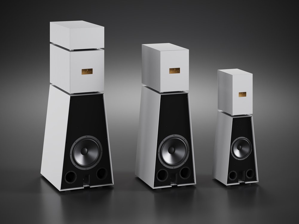 Three Goldmund active loudspeakers in grey aluminium, from the front on a dark ground, tallest to smallest