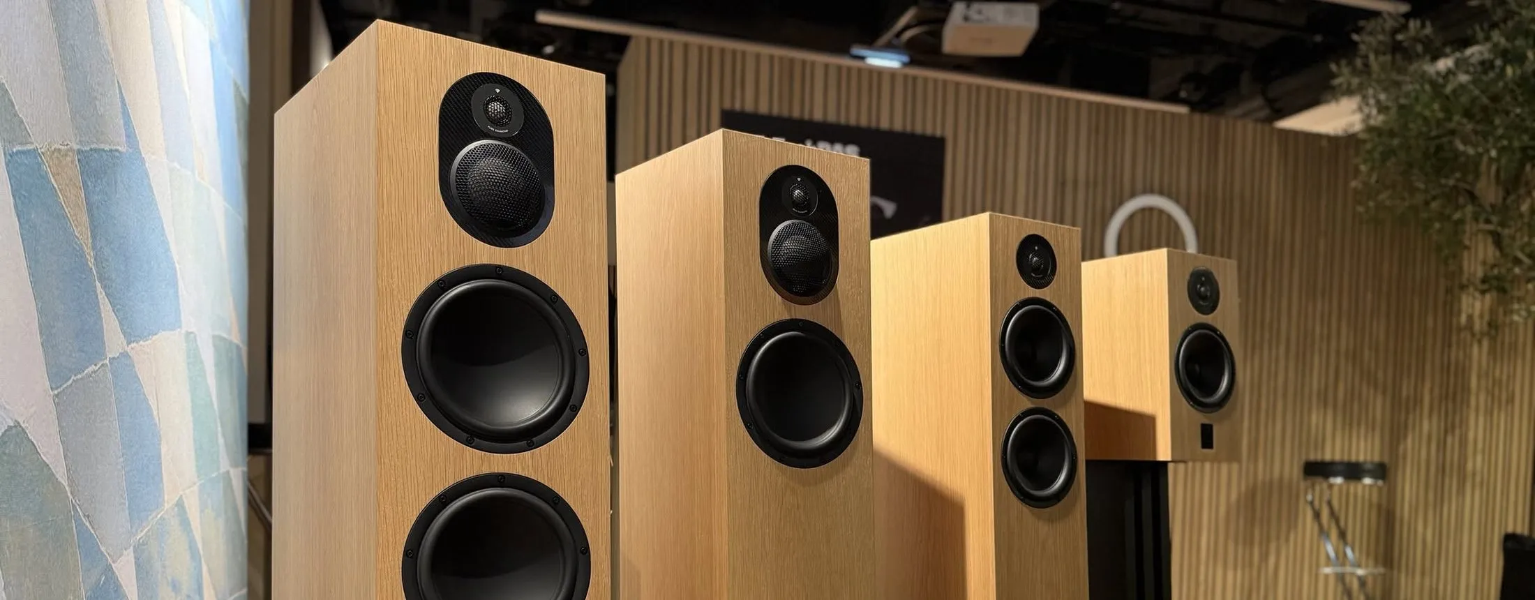 Four Marten Dexter models in oak on a black plinth, with veneer samples beside them