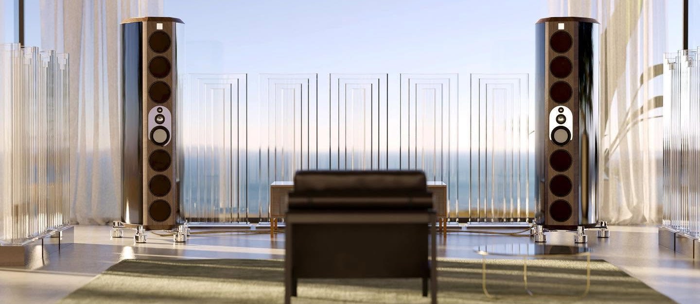 Two loudspeakers and a chair in a room with a view of the sea