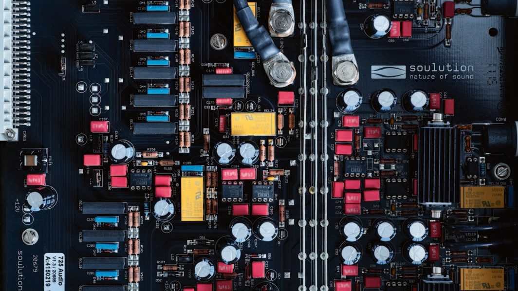 A soulution circuit board from above, black with red and yellow components