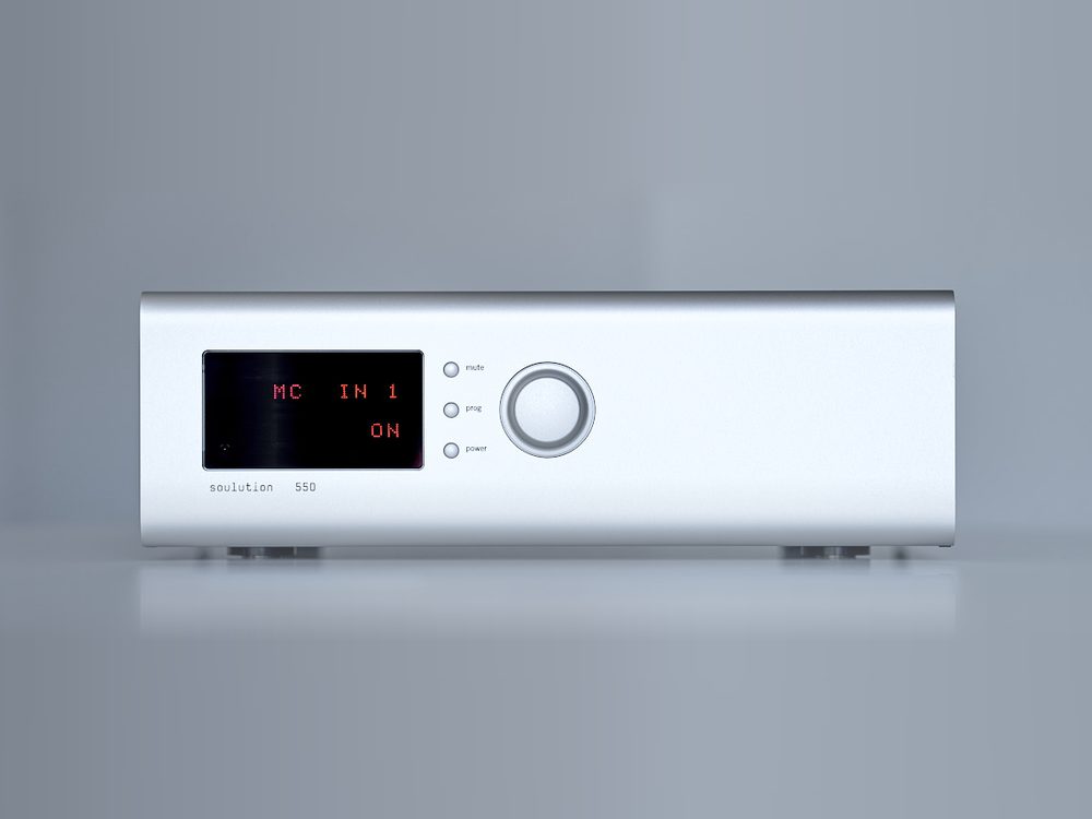 A soulution 550 phono stage in silver on a grey ground, its red display lit