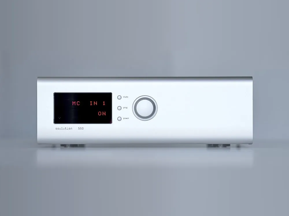 A soulution 550 phono stage in silver on a grey ground, its red display lit