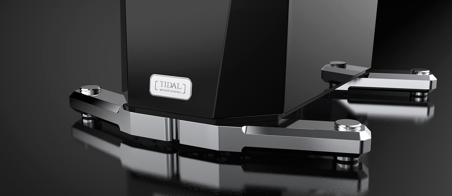 The polished aluminium foot of a TIDAL loudspeaker in black lacquer, its nameplate above, on a black floor