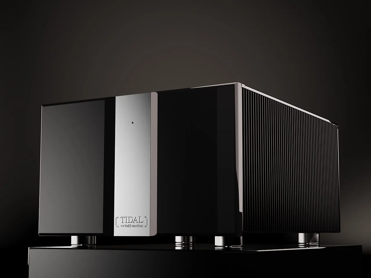 A Ferios monoblock power amplifier in black lacquer with a chrome centre, on black