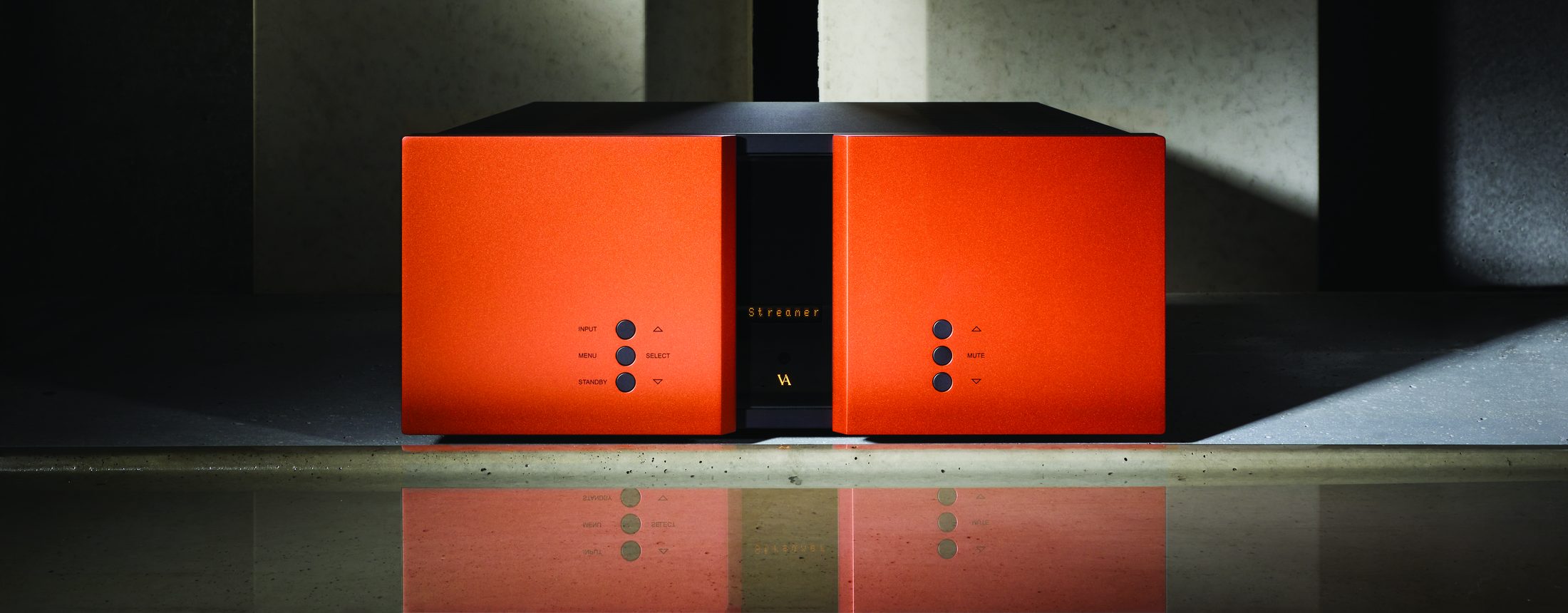 An orange RI-101 in a concrete room, lit from above