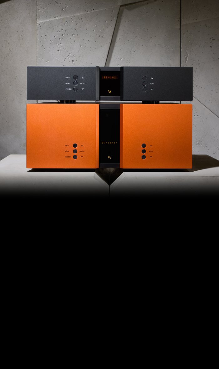 An RP-102 phono stage in orange under a black RD-101, on a concrete plinth