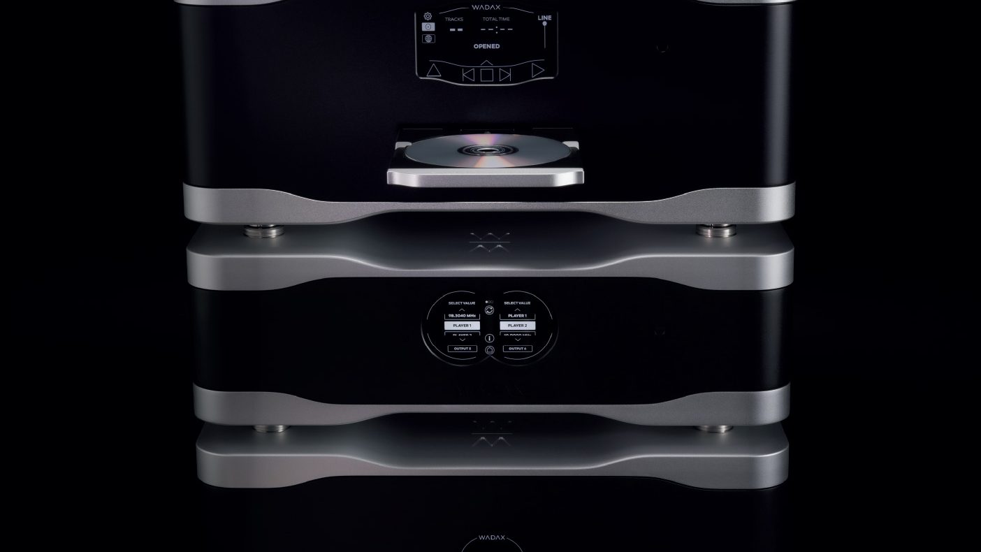 A stack of Studio Player components in black and silver, a disc drawer open, on black